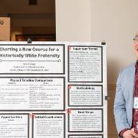 Social Innovation graduate student, Ty Krueger, standing in front of his poster.